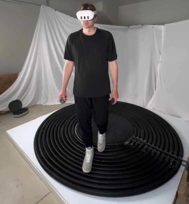 Person wearing a VR headset walking on the OmniTrek omnidirectional treadmill prototype.